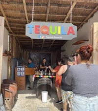 a group of people standing in front of a tequila bar